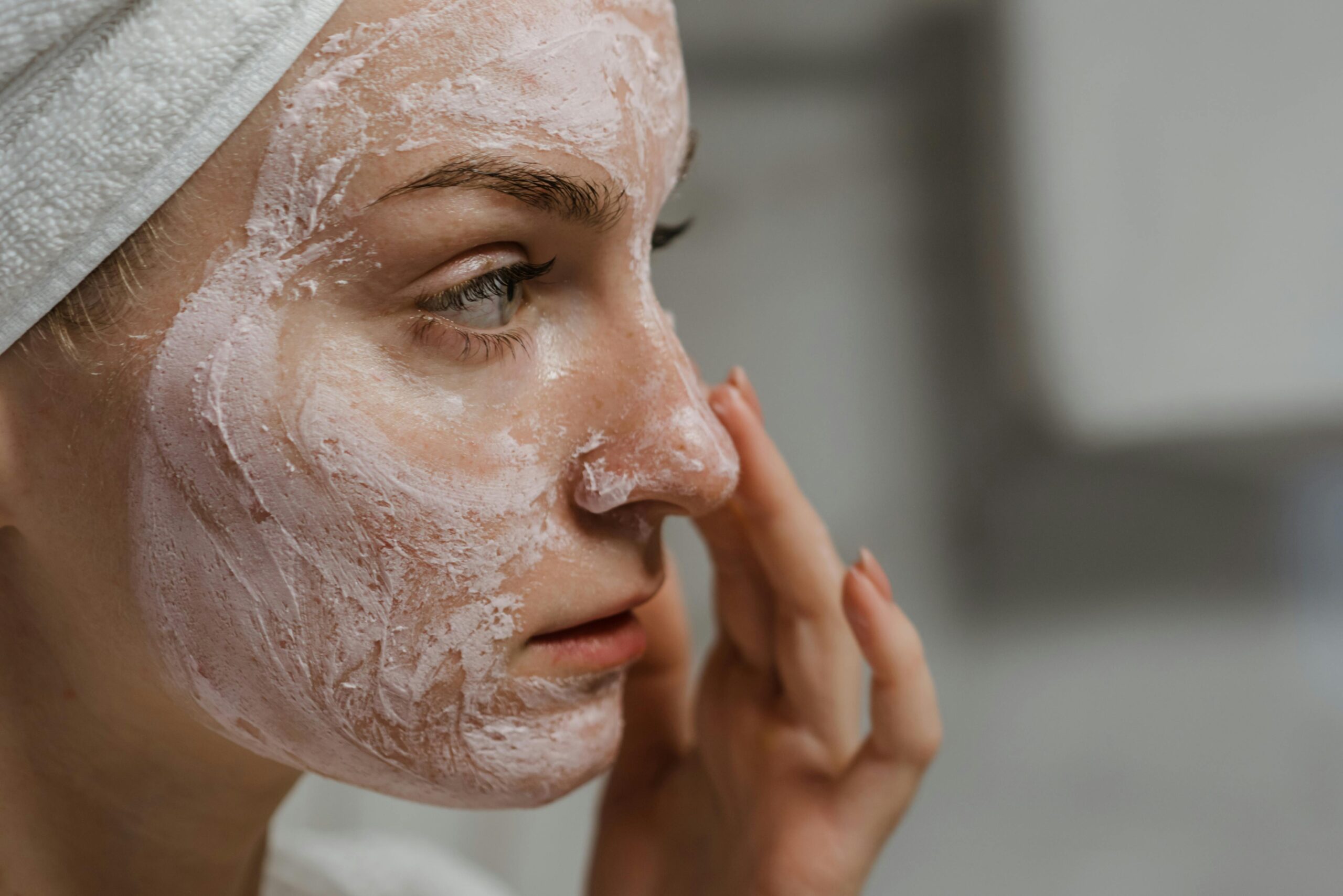 beautiful young lady applying face mask on her skin